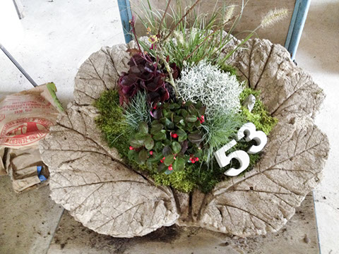 Grinsender Beton-Kopf als Gartendekoration