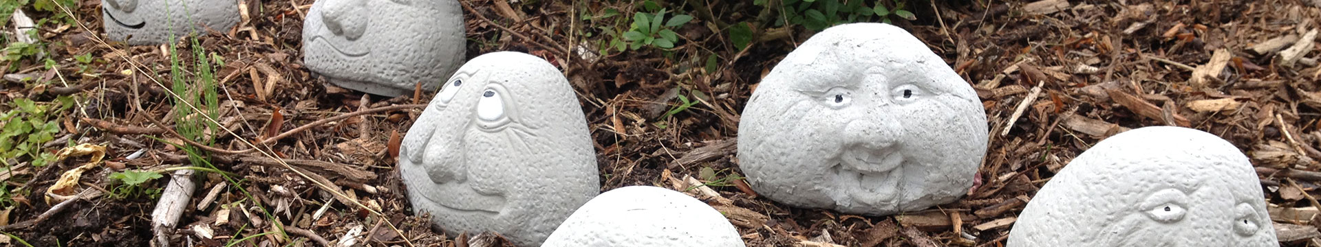 Anordnung mehrerer Beton-Köpfe im Garten