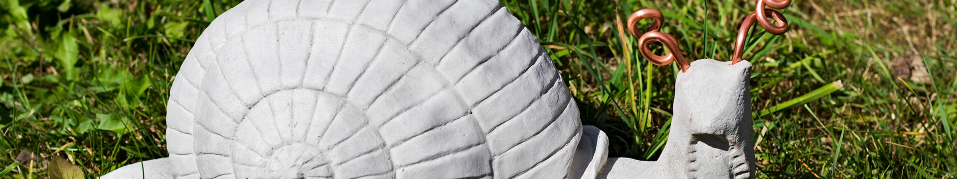 Nahaufnahme einer Beton-Schnecke im Garten